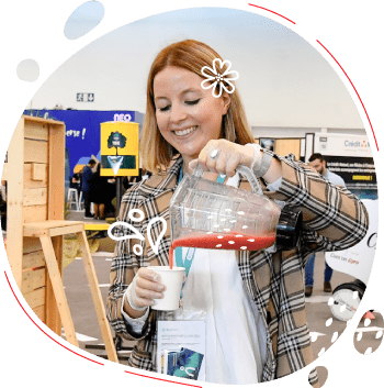 une femme verse du smoothie biologique réalisé au vélo mixeur dans un gobelet compostable lors d'un evenement corporate au parc expo de caen